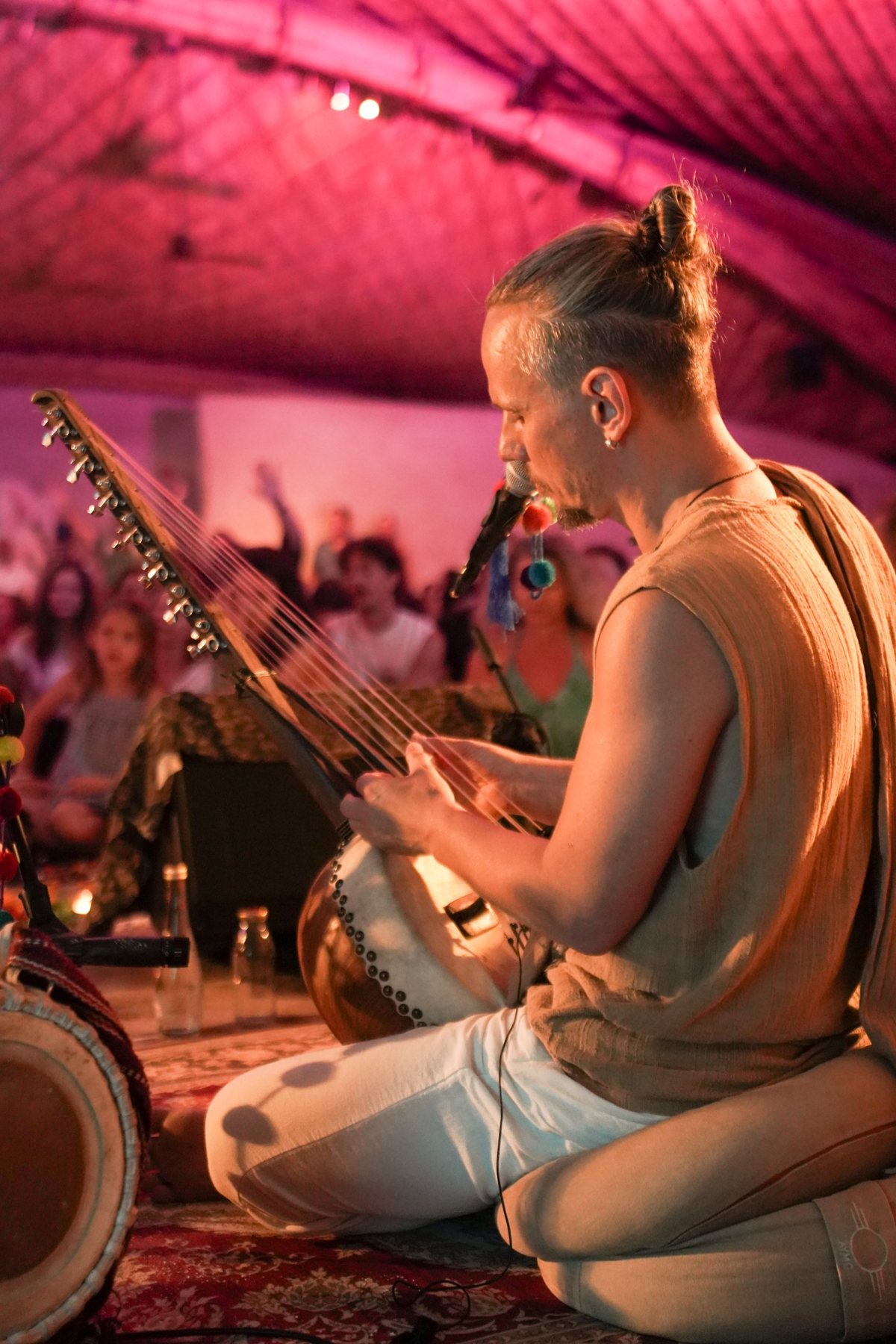 Acharya playing kora and singing to a seated audience