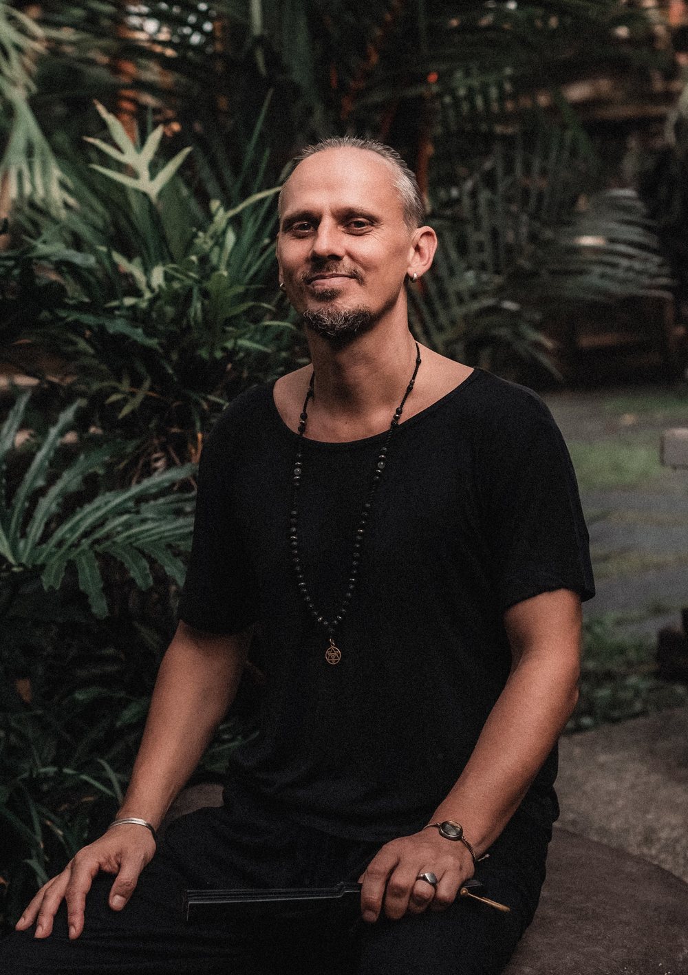 Portrait of Acharya seated among tropical plants in Ubud